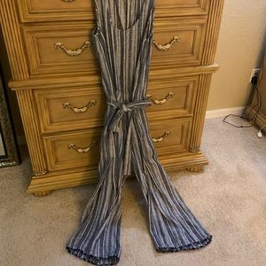 Denim/white striped jump suit with fringed bottom.